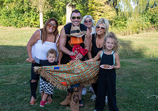 family holding a scarecrow they made