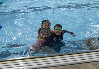 three kids playing in a pool